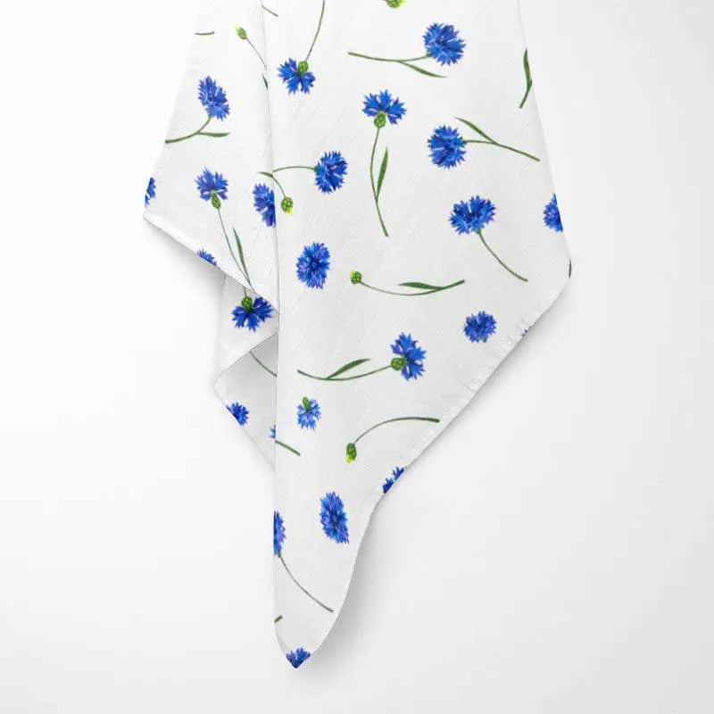 close-up of white bamboo baby blanket texture showing soft weave and vibrant blue cornflower design