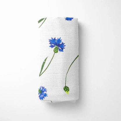 rolled white bamboo baby blanket showing blue floral pattern, compact for diaper bag storage