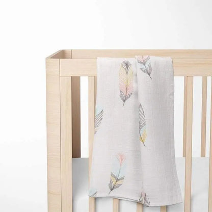 bamboo baby blanket with colorful leaf design displayed on crib showing perfect size and nursery integration