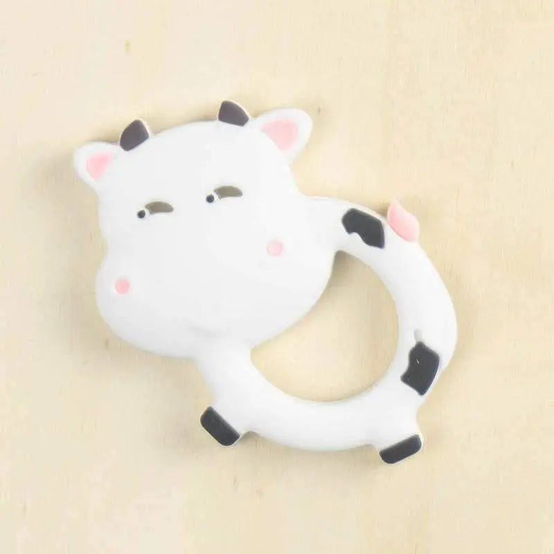 white cow silicone teether with spotted design and textured ring for baby teething relief