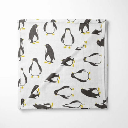 white organic cotton baby blanket with black and yellow penguin pattern double-layer design displayed flat showing playful arctic animals