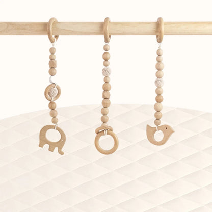 Front view of Wooden Animals Play Gym with three natural wood toys visible showcasing minimalist Montessori aesthetic