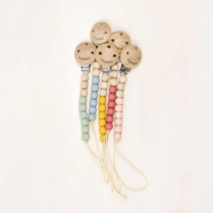 set of wooden and silicone pacifier clips with cookie-shaped charm in five different colors